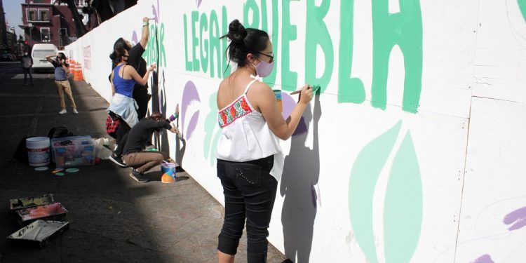 Feministas pintan muro provisional en el zócalo de Puebla en pro de la legalización del aborto