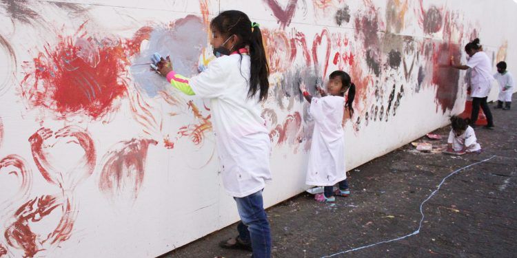 Niños en situación de calle utilizan muro del zócalo de Puebla como lienzo 